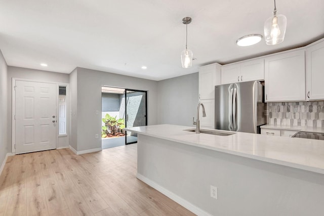 5192 Cedar Hammock Ln, Sarasota, FL 34232 - kitchen featuring a sink, freestanding refrigerator, white cabinets, baseboards, and light wood finished floors