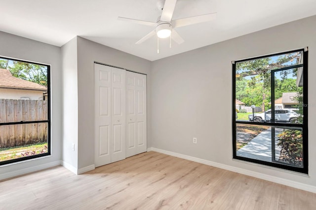 5192 Cedar Hammock Ln, Sarasota, FL 34232 - unfurnished bedroom with multiple windows, light wood finished floors, baseboards, and a closet