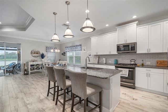 10423 Morning Marsh Ln, Parrish, FL 34219 - kitchen with appliances with stainless steel finishes, a sink, crown molding, healthy amount of natural light, and dark stone countertops