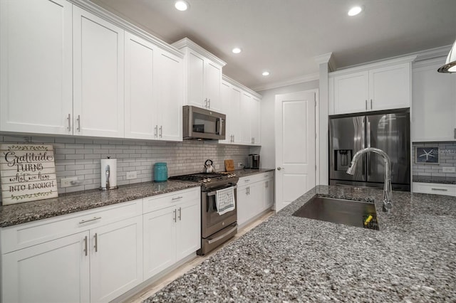 10423 Morning Marsh Ln, Parrish, FL 34219 - kitchen featuring stainless steel appliances, a sink, tasteful backsplash, white cabinets, and dark stone counters