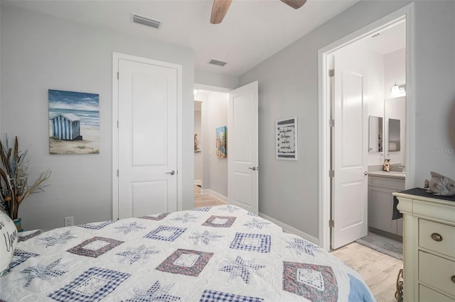 10423 Morning Marsh Ln, Parrish, FL 34219 - bedroom with light wood-style floors, ensuite bath, a ceiling fan, and baseboards