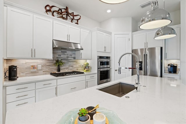 5740 Eagle Creek Rd, Sarasota, FL 34238 - kitchen featuring a sink, stainless steel appliances, under cabinet range hood, white cabinetry, and decorative backsplash