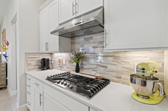 5740 Eagle Creek Rd, Sarasota, FL 34238 - kitchen with under cabinet range hood, stainless steel gas stovetop, decorative backsplash, white cabinets, and light countertops