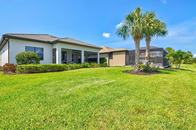 5740 Eagle Creek Rd, Sarasota, FL 34238 - back of property with a lawn, stucco siding, and a tiled roof