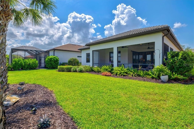 5740 Eagle Creek Rd, Sarasota, FL 34238 - rear view of property featuring a ceiling fan, a yard, stucco siding, and a tile roof