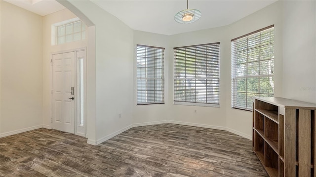 6213 Willet Ct, Lakewood Ranch, FL 34202 - unfurnished dining area with arched walkways, dark wood-style floors, and baseboards