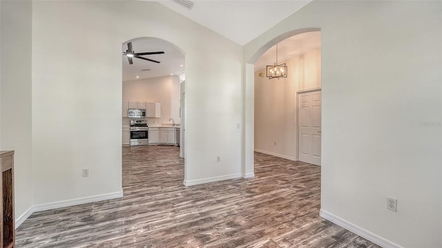 6213 Willet Ct, Lakewood Ranch, FL 34202 - hall featuring dark wood finished floors, arched walkways, a chandelier, baseboards, and high vaulted ceiling