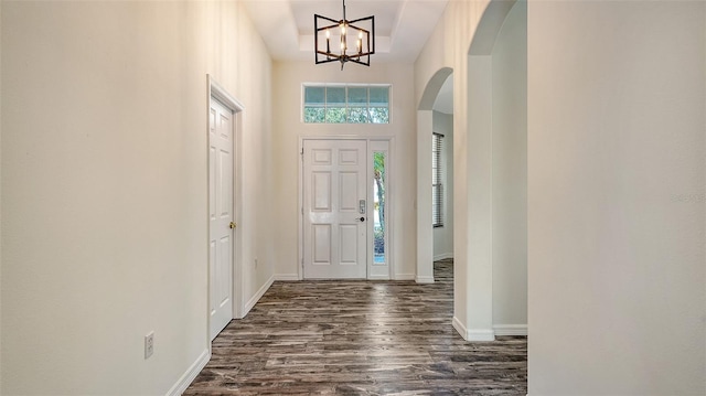 6213 Willet Ct, Lakewood Ranch, FL 34202 - entrance foyer with arched walkways, dark wood-type flooring, a chandelier, baseboards, and a towering ceiling