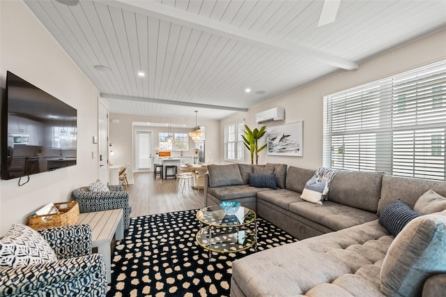 4321 Marina View Way, Cortez, FL 34215 - living area featuring a wall mounted AC, plenty of natural light, beamed ceiling, recessed lighting, and wood finished floors