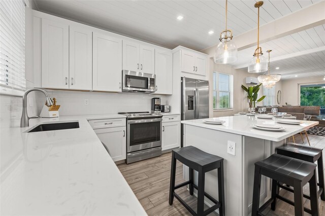 4321 Marina View Way, Cortez, FL 34215 - kitchen with stainless steel appliances, a sink, a kitchen island, wooden ceiling with exposed beams, and a breakfast bar