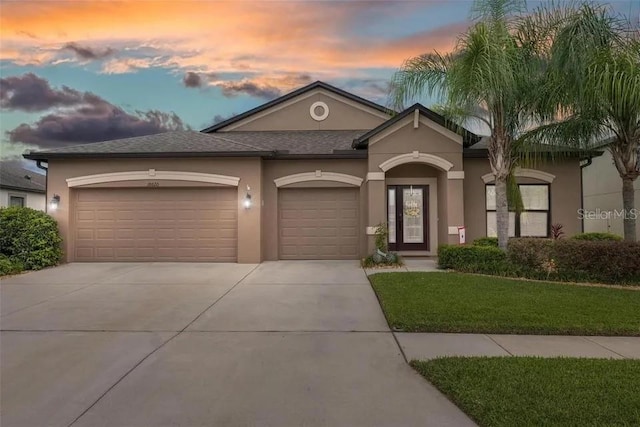 18620 Cortes Creek Blvd, Spring Hill, FL 34610 - view of front of property with driveway, an attached garage, stucco siding, and a lawn