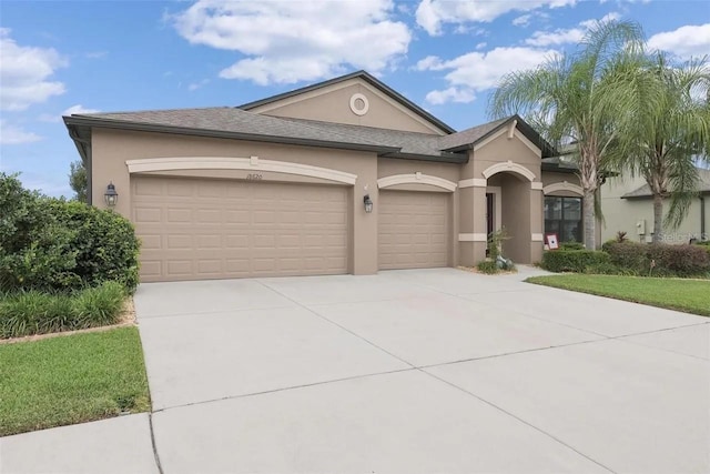 18620 Cortes Creek Blvd, Spring Hill, FL 34610 - view of front facade featuring stucco siding, an attached garage, and driveway