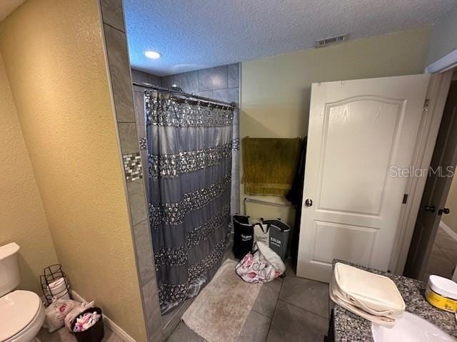 2094 Penn Dr, Deland, FL 32724 - bathroom featuring toilet, curtained shower, a textured ceiling, tile patterned floors, and recessed lighting