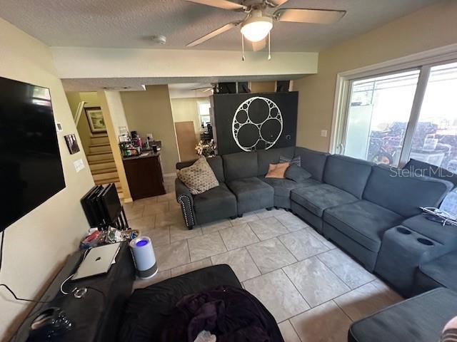 2094 Penn Dr, Deland, FL 32724 - living room with a ceiling fan, plenty of natural light, and stairs