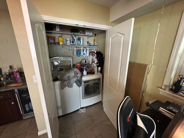 2094 Penn Dr, Deland, FL 32724 - laundry area with dark tile patterned flooring and washer and clothes dryer