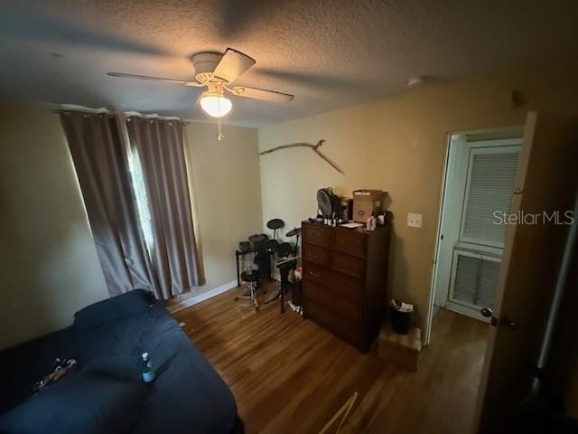 2094 Penn Dr, Deland, FL 32724 - bedroom with wood finished floors, a ceiling fan, a textured ceiling, and baseboards