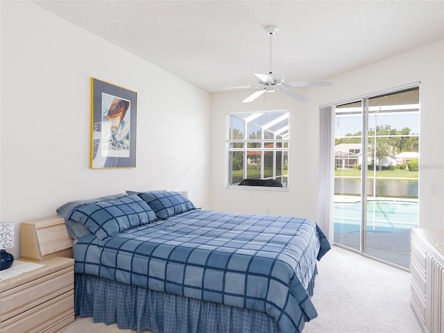 4257 Hearthstone Dr, Sarasota, FL 34238 - bedroom featuring light colored carpet, access to outside, a water view, a textured ceiling, and a ceiling fan