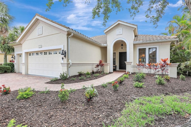 12710 Stone Ridge Pl, Lakewood Ranch, FL 34202 - mediterranean / spanish-style house featuring a tile roof, a garage, stucco siding, and decorative driveway