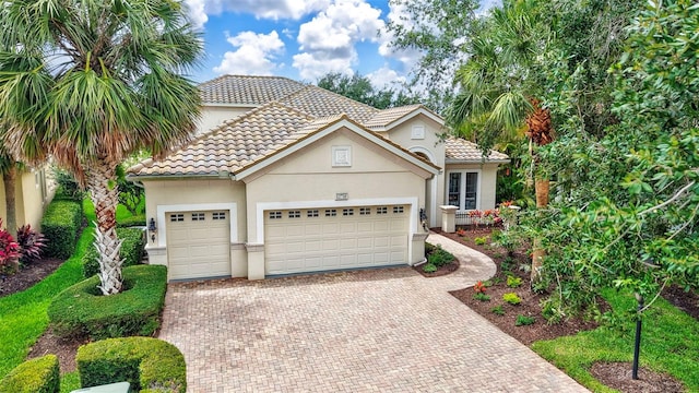 12710 Stone Ridge Pl, Lakewood Ranch, FL 34202 - view of front of house featuring decorative driveway, an attached garage, stucco siding, and a tile roof