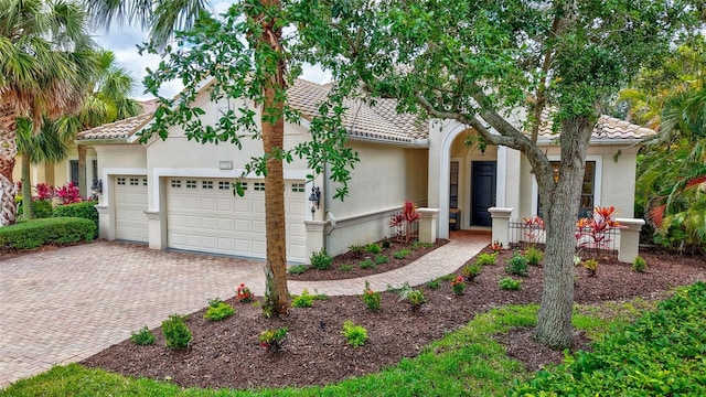 12710 Stone Ridge Pl, Lakewood Ranch, FL 34202 - view of front of house with a garage, a tile roof, decorative driveway, and stucco siding