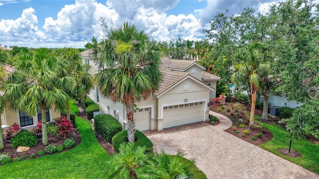 12710 Stone Ridge Pl, Lakewood Ranch, FL 34202 - view of front of property featuring stucco siding, a garage, decorative driveway, a tiled roof, and central AC