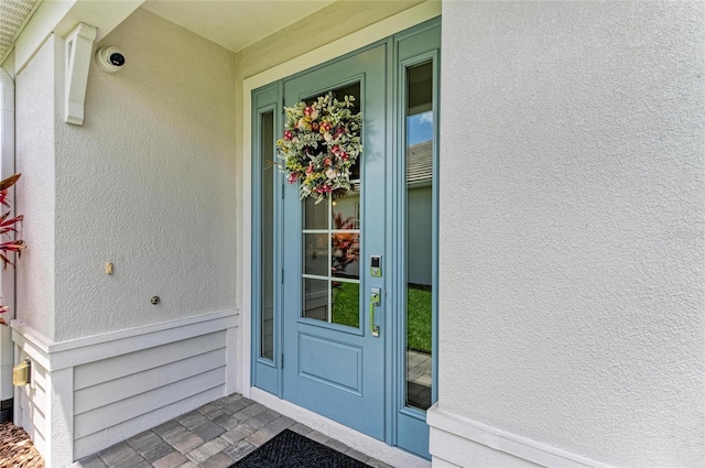 909 Crosswind Ave, Sarasota, FL 34240 - doorway to property with stucco siding and a security system