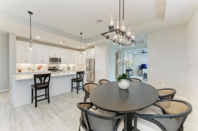 909 Crosswind Ave, Sarasota, FL 34240 - dining space featuring recessed lighting, light wood-type flooring, baseboards, and a raised ceiling