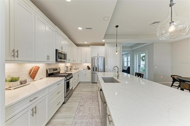 909 Crosswind Ave, Sarasota, FL 34240 - kitchen with appliances with stainless steel finishes, a sink, recessed lighting, white cabinets, and tasteful backsplash