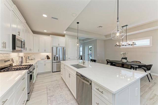 909 Crosswind Ave, Sarasota, FL 34240 - kitchen with appliances with stainless steel finishes, a sink, an island with sink, white cabinetry, and recessed lighting