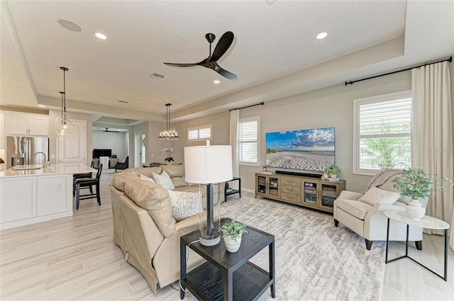 909 Crosswind Ave, Sarasota, FL 34240 - living area with ceiling fan, a tray ceiling, plenty of natural light, light wood-type flooring, and recessed lighting
