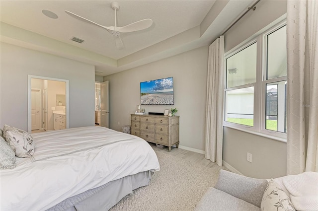 909 Crosswind Ave, Sarasota, FL 34240 - bedroom with light carpet, ensuite bath, baseboards, ceiling fan, and a tray ceiling