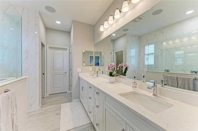 909 Crosswind Ave, Sarasota, FL 34240 - bathroom with double vanity, wood finished floors, a walk in shower, and recessed lighting