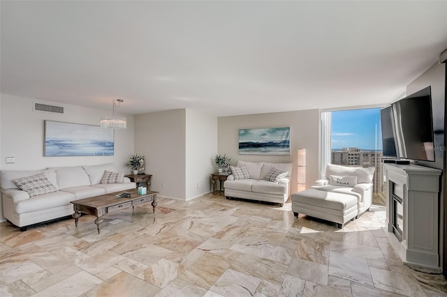 2425 Gulf Of Mexico Dr Unit 14B, Longboat Key, FL 34228 - living area featuring a chandelier, light marble finish flooring, baseboards, and a glass covered fireplace