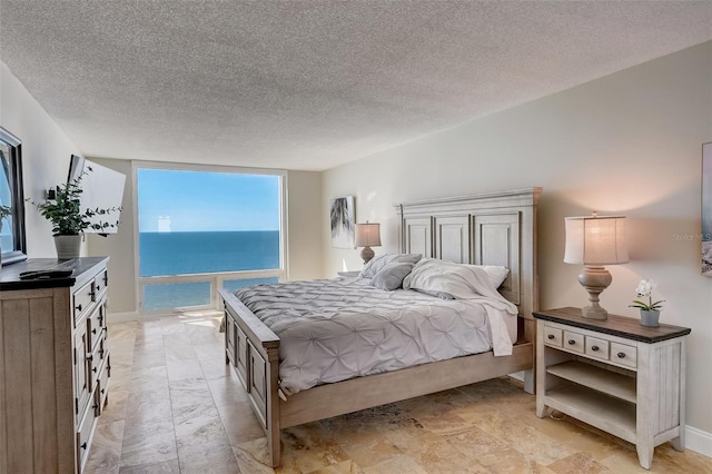 2425 Gulf Of Mexico Dr Unit 14B, Longboat Key, FL 34228 - bedroom featuring a textured ceiling and baseboards