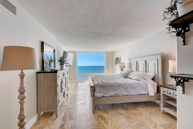 2425 Gulf Of Mexico Dr Unit 14B, Longboat Key, FL 34228 - bedroom featuring a textured ceiling and baseboards