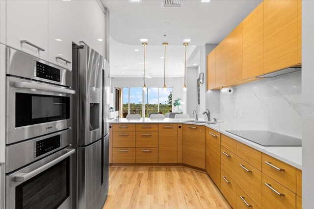 5450 Eagles Point Cir Unit 404, Sarasota, FL 34231 - kitchen with appliances with stainless steel finishes, a sink, light wood-type flooring, light countertops, and modern cabinets