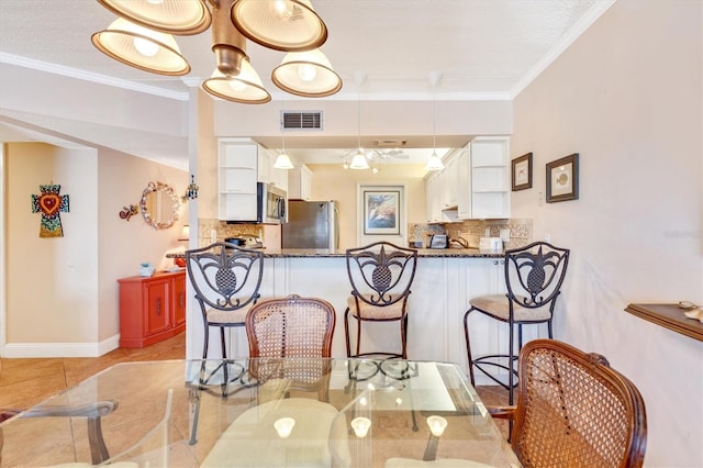 3806 Gulf Of Mexico Dr Unit C204, Longboat Key, FL 34228 - dining room featuring crown molding, light tile patterned flooring, and baseboards
