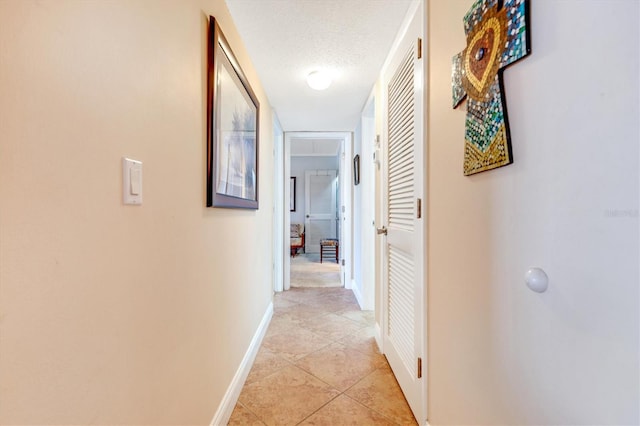 3806 Gulf Of Mexico Dr Unit C204, Longboat Key, FL 34228 - hall with baseboards, a textured ceiling, and light tile patterned flooring