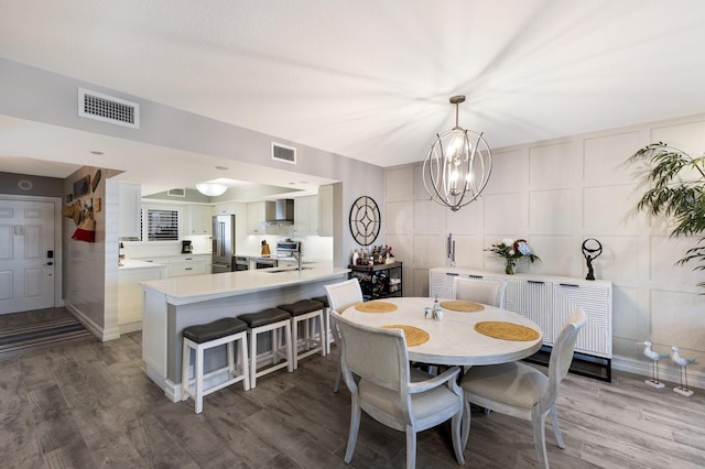 1445 Gulf Of Mexico Dr Unit 203, Longboat Key, FL 34228 - dining room with a chandelier and wood finished floors