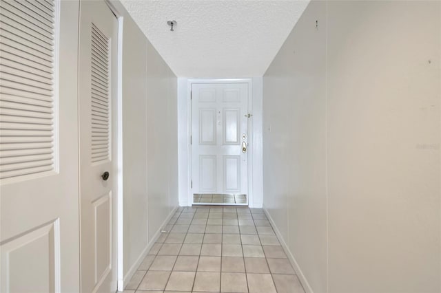 3630 Gulf Of Mexico Dr Unit 202, Longboat Key, FL 34228 - hall with a textured ceiling, light tile patterned flooring, and baseboards