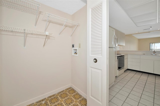 3630 Gulf Of Mexico Dr Unit 202, Longboat Key, FL 34228 - laundry room featuring electric dryer hookup, washer hookup, baseboards, and light tile patterned floors