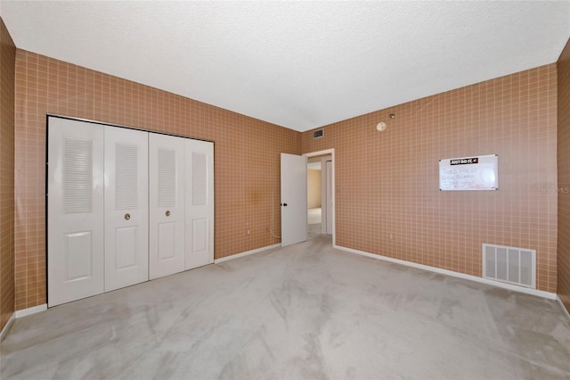3630 Gulf Of Mexico Dr Unit 202, Longboat Key, FL 34228 - unfurnished bedroom with a closet, carpet, baseboards, and a textured ceiling
