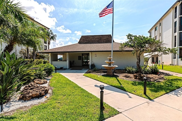 3630 Gulf Of Mexico Dr Unit 202, Longboat Key, FL 34228 - view of front of house featuring a front lawn, stucco siding, and a shingled roof