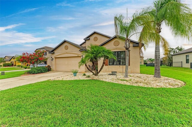 7410 61st St E, Palmetto, FL 34221 - view of front of property featuring stucco siding, driveway, and a garage