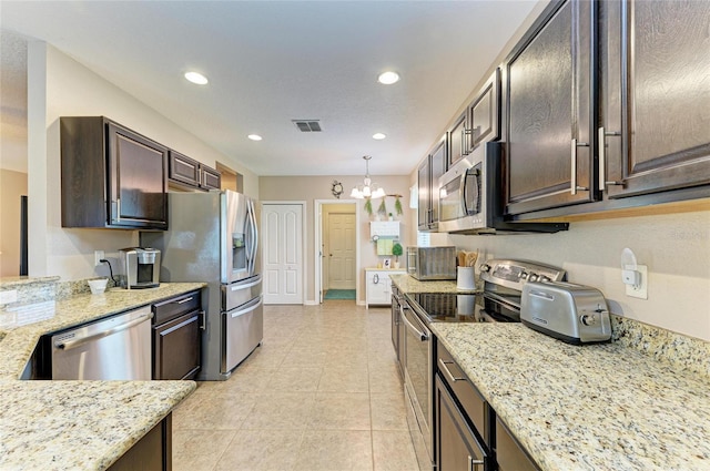 7410 61st St E, Palmetto, FL 34221 - kitchen featuring stainless steel appliances, a chandelier, dark brown cabinetry, recessed lighting, and light stone countertops