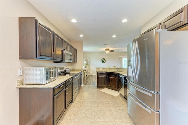 7410 61st St E, Palmetto, FL 34221 - kitchen with appliances with stainless steel finishes, dark brown cabinetry, recessed lighting, a peninsula, and a ceiling fan