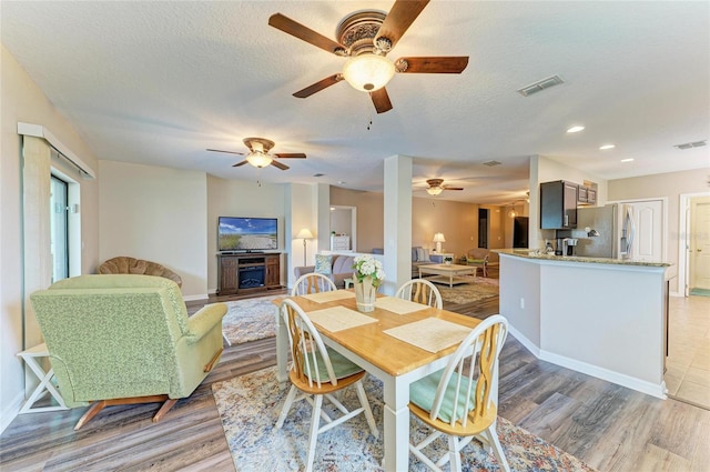 7410 61st St E, Palmetto, FL 34221 - dining space with light wood finished floors, ceiling fan, a textured ceiling, and recessed lighting