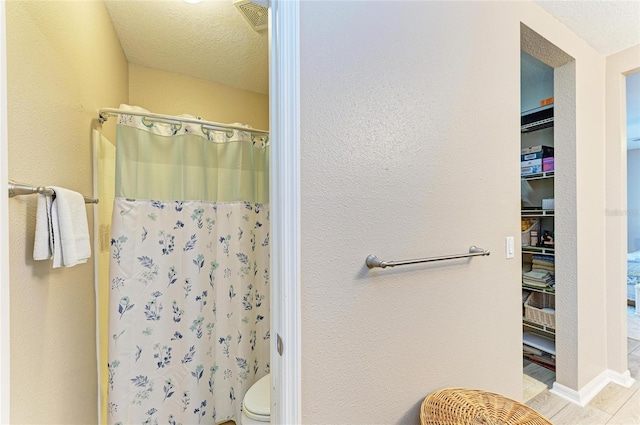 7410 61st St E, Palmetto, FL 34221 - bathroom featuring curtained shower, a textured ceiling, and a textured wall