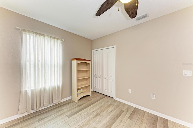 7410 61st St E, Palmetto, FL 34221 - unfurnished bedroom featuring light wood-style flooring, a closet, and ceiling fan