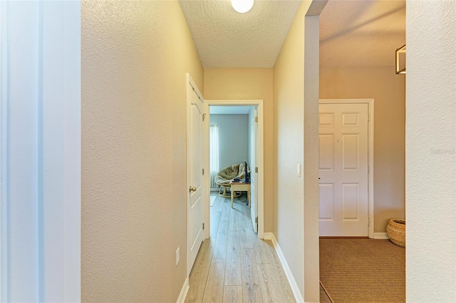 7410 61st St E, Palmetto, FL 34221 - corridor featuring light wood-style floors, a textured wall, and a textured ceiling